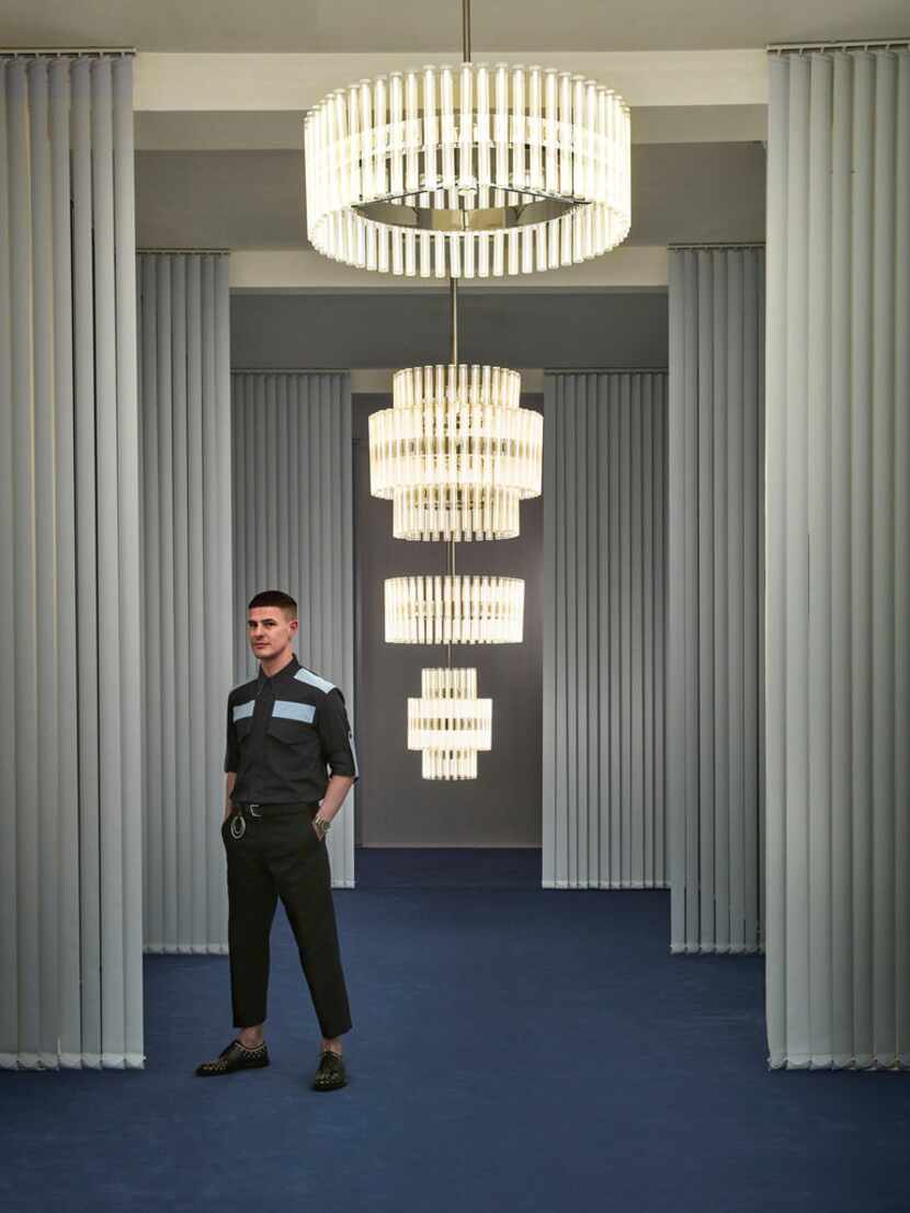 British designer Lee Broom poses with his Aurora Chandeliers. The hand-blown glass bulbs...