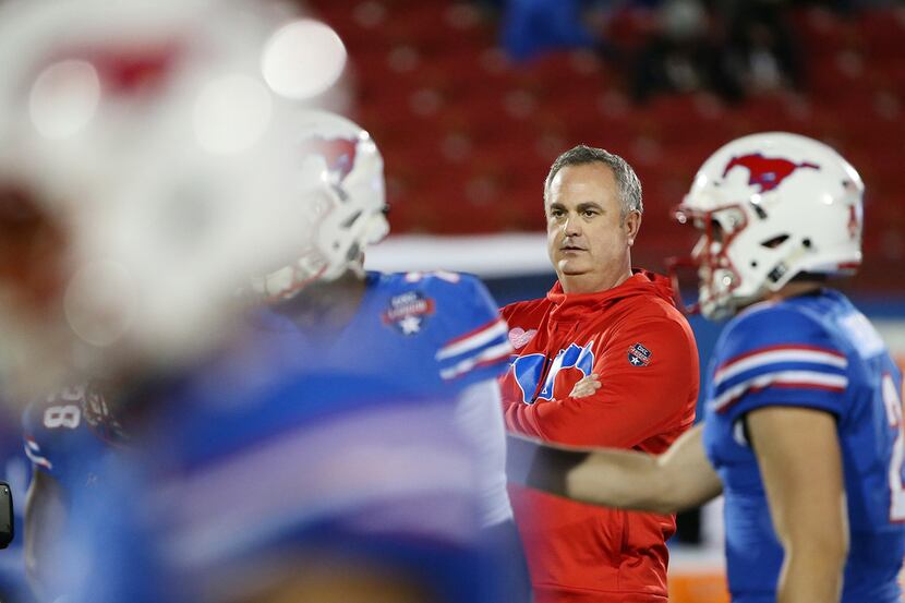 New Southern Methodist Mustangs head coach Sonny Dykes watches his team warm up before the...