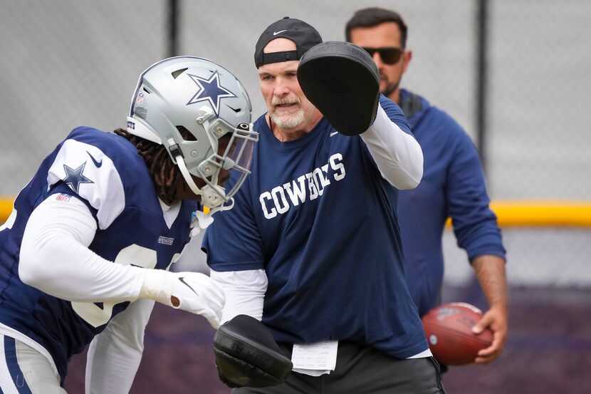 Dallas Cowboys defensive coordinator Dan Quinn works with defensive ends during a practice...