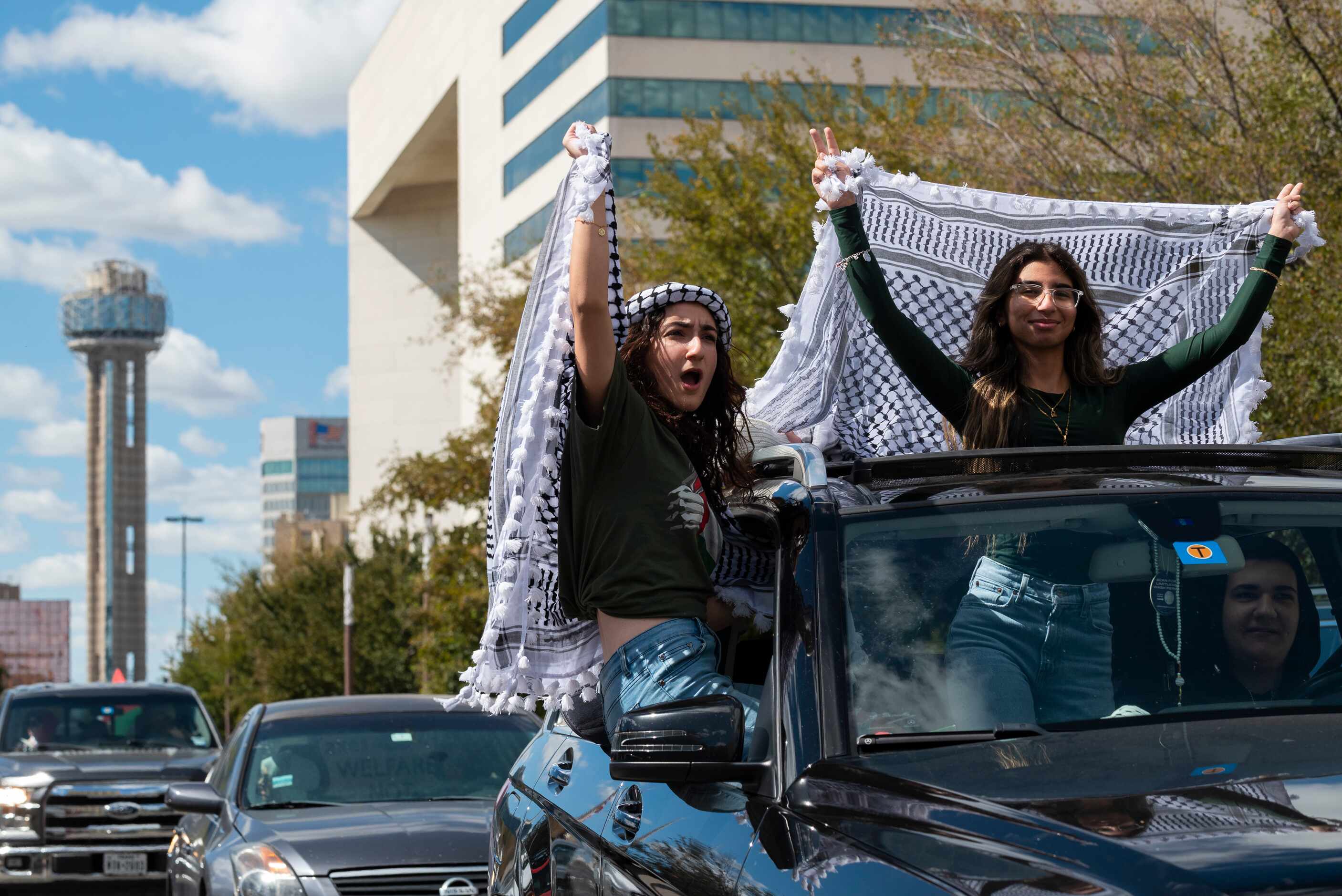 Manar Khalaf, 19, left, and Haya Sharif, 19, wave traditional Palestinian clothing and...