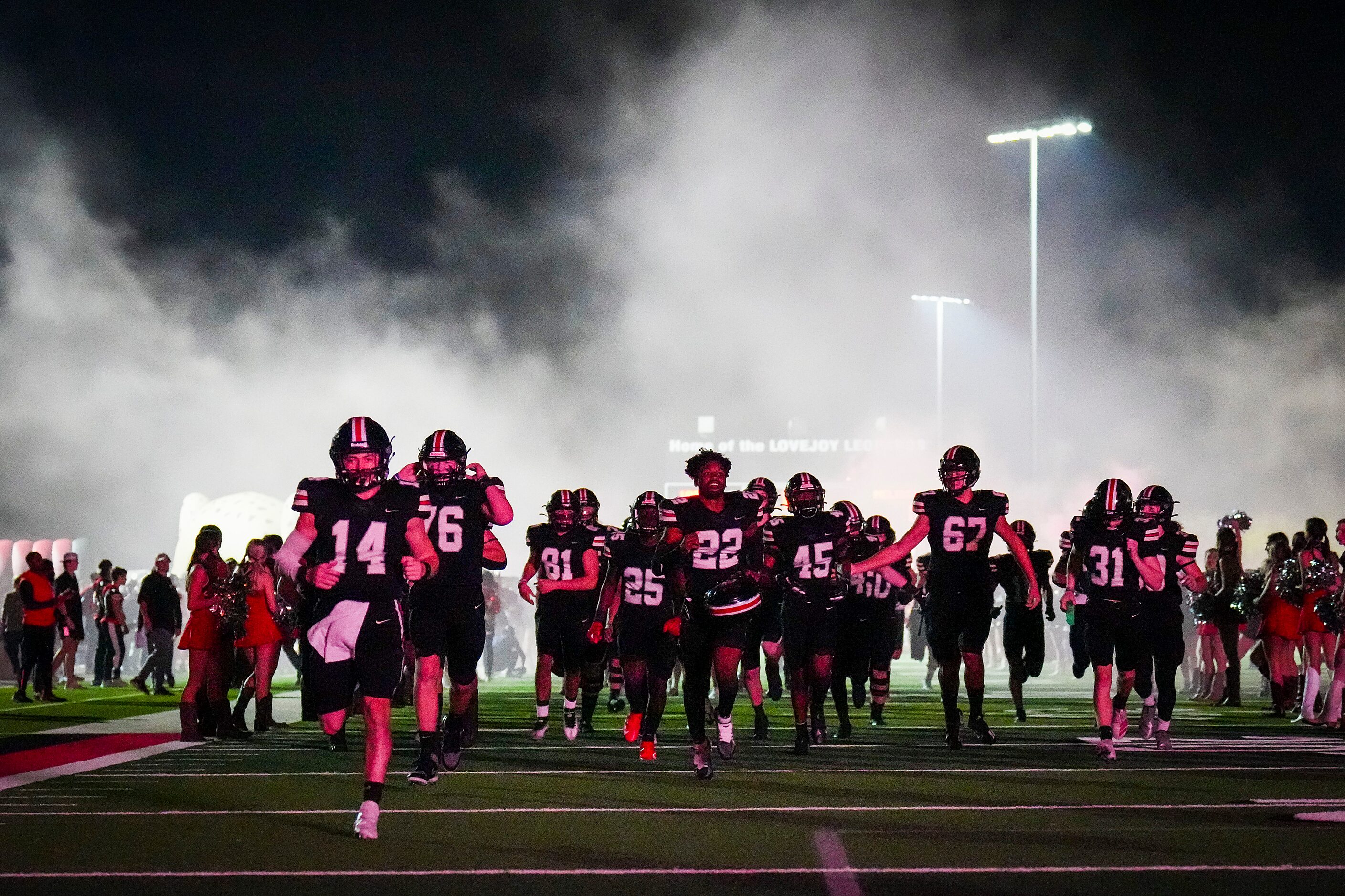 Lovejoy players, including Austin Gonzalez (14), take the field to face Melissa before a...