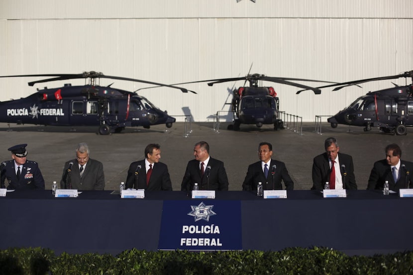 Mexico's Secretary of Public Safety Genaro Garcia Luna, center, speaks with U.S. Ambassador...