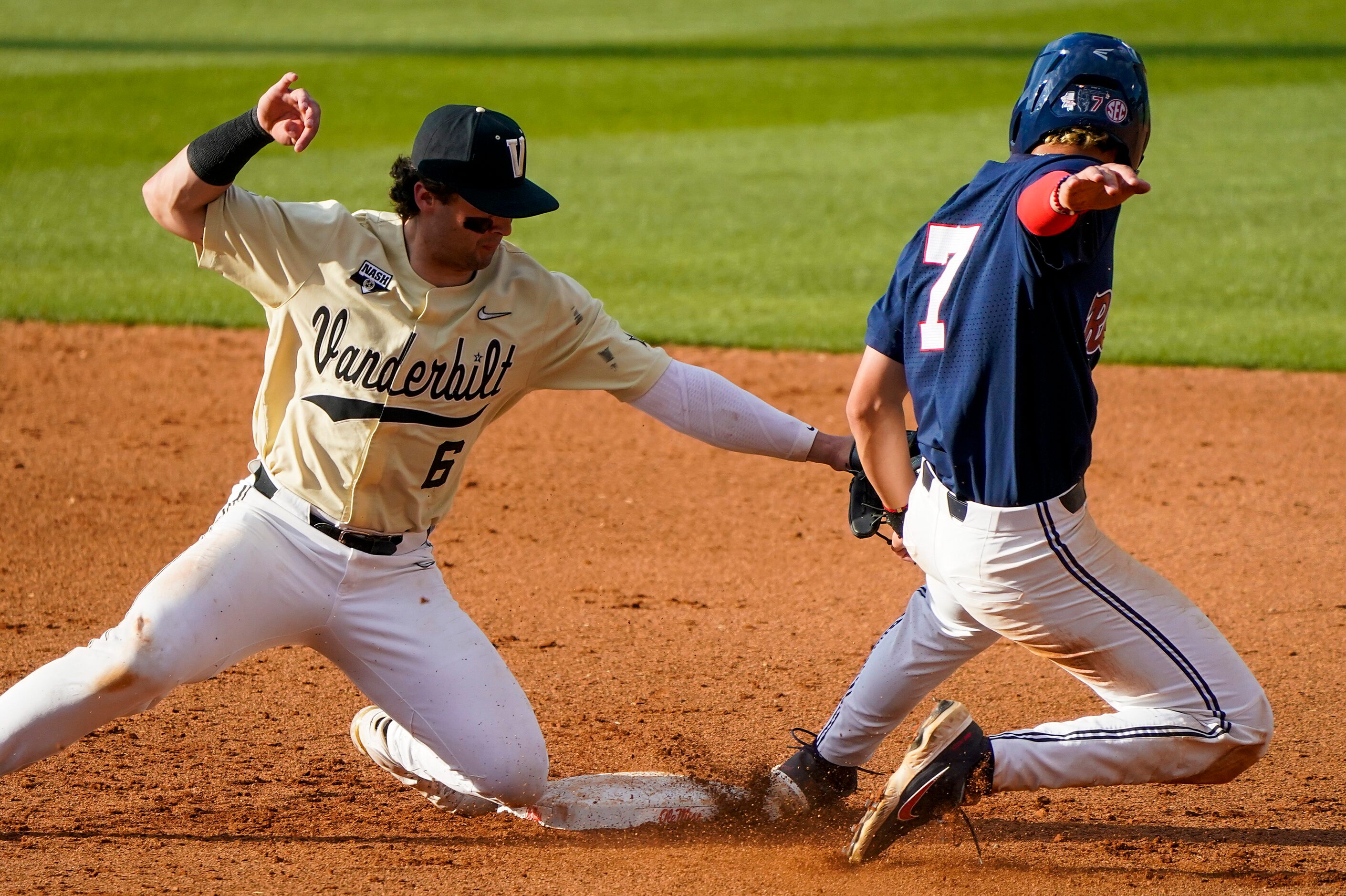 Mississippi infielder Jacob Gonzalez gets past the tag of Vanderbilt infielder Tate Kolwyck...