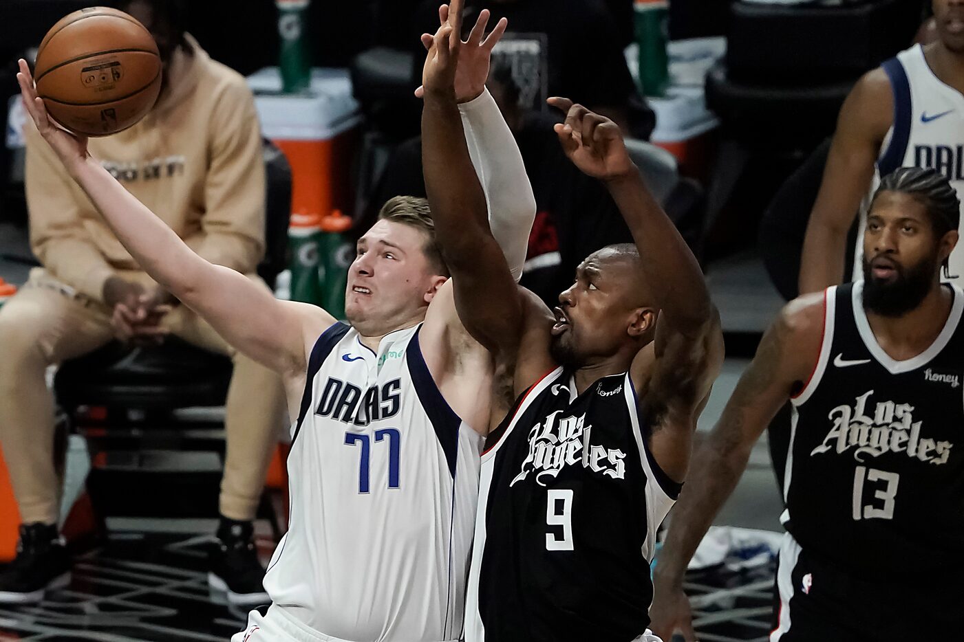 Dallas Mavericks guard Luka Doncic (77) drives to the basket past LA Clippers center Serge...