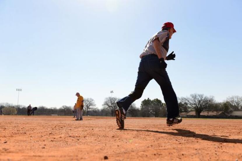Art Latimer, 82, runs to first base after hitting the softball into the outfield during an...