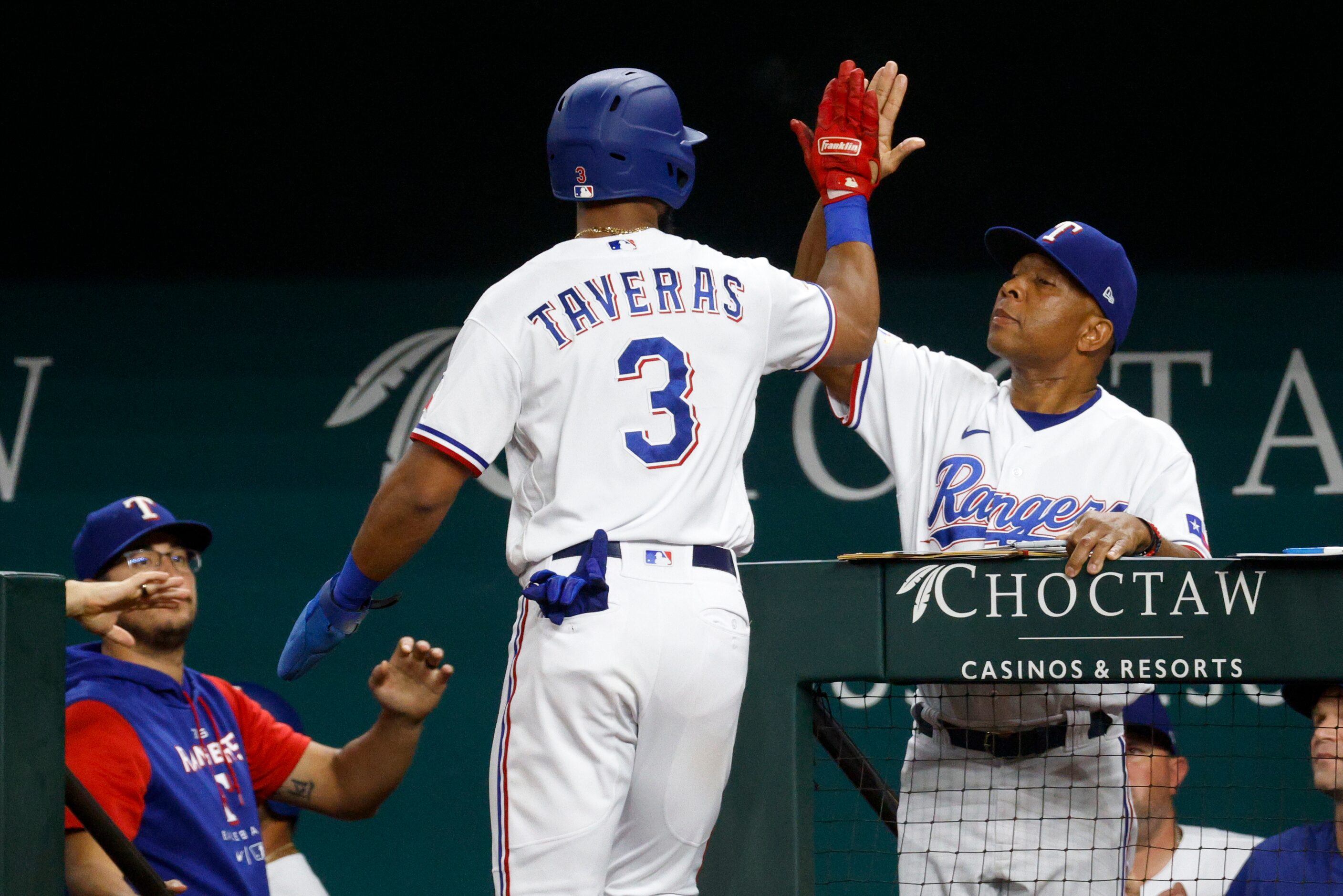 Texas Rangers center fielder Leody Taveras (3) high-fives interim manager Tony Beasley (27)...