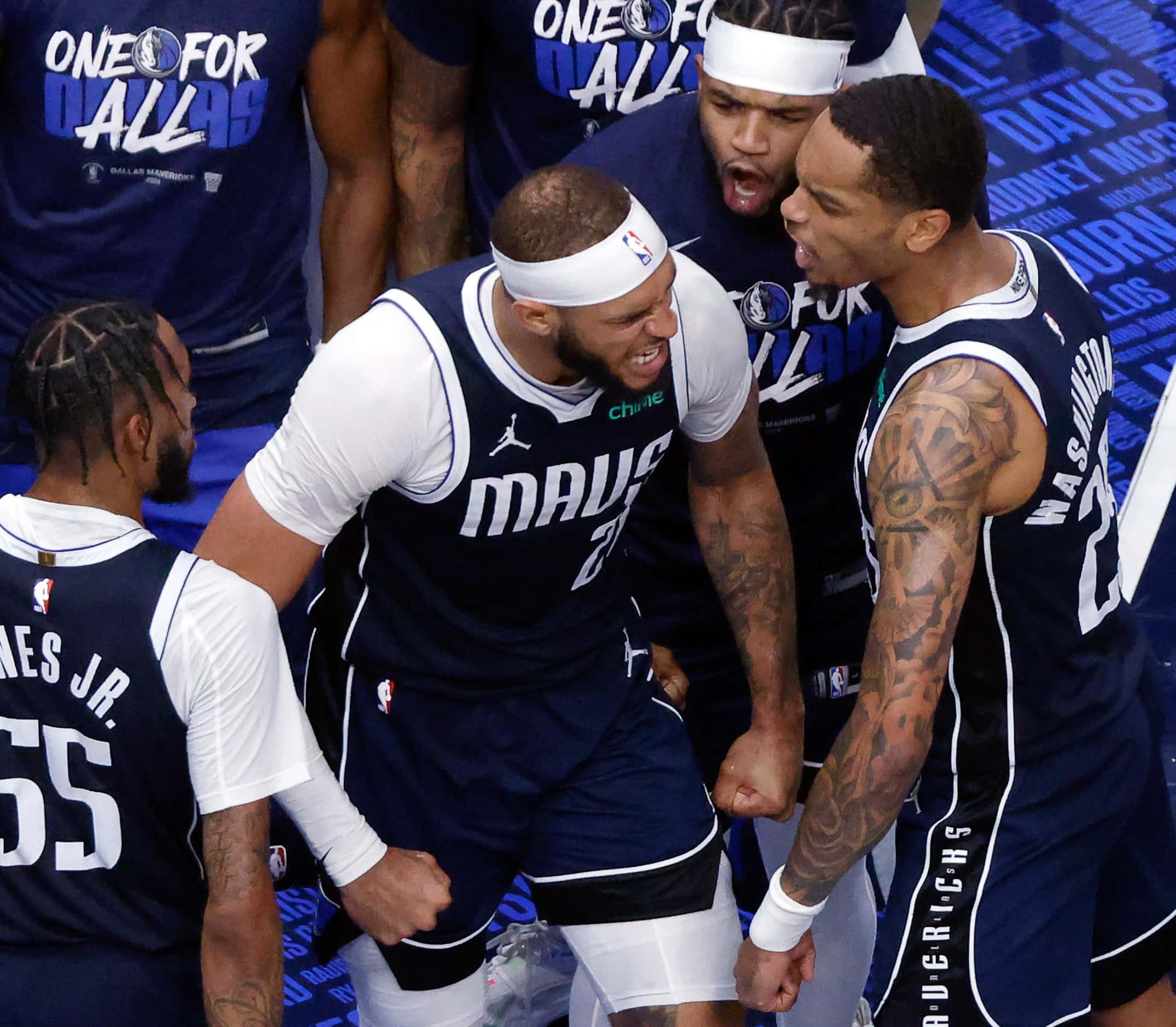 Dallas Mavericks center Daniel Gafford (21) is congratulated by teammates after dunking the...