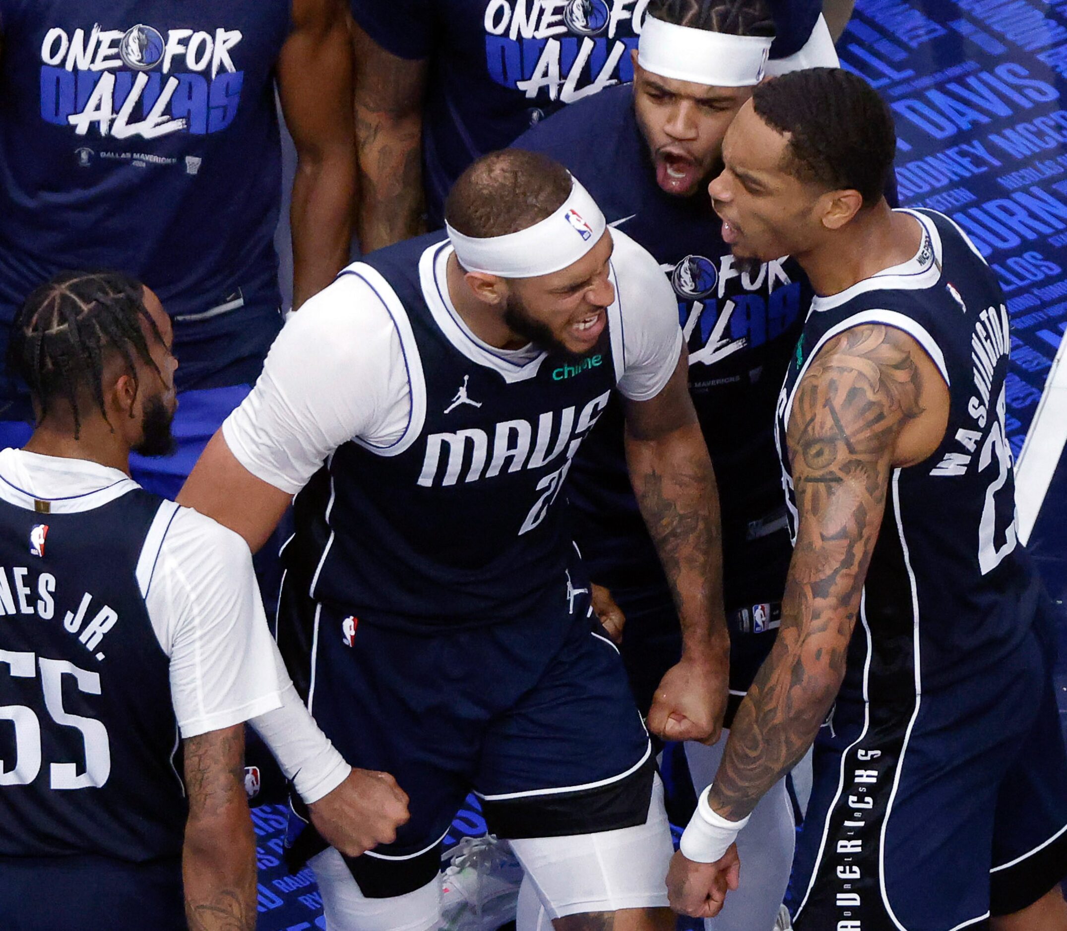 Dallas Mavericks center Daniel Gafford (21) is congratulated by teammates after dunking the...