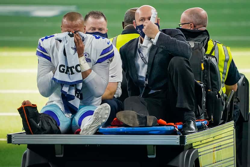 Dallas Cowboys quarterback Dak Prescott leaves the field on a cart after being injured on a...