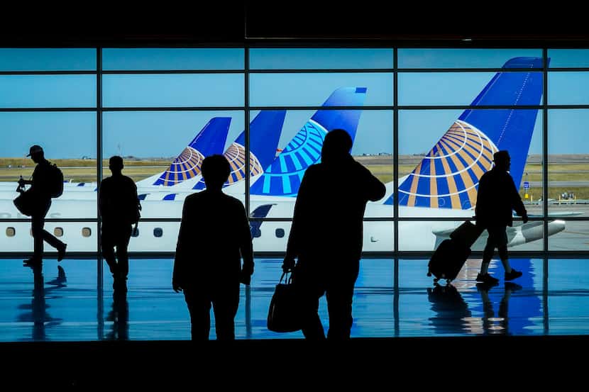 Passengers pass United Airlines aircraft at the gates at Denver International Airport on...
