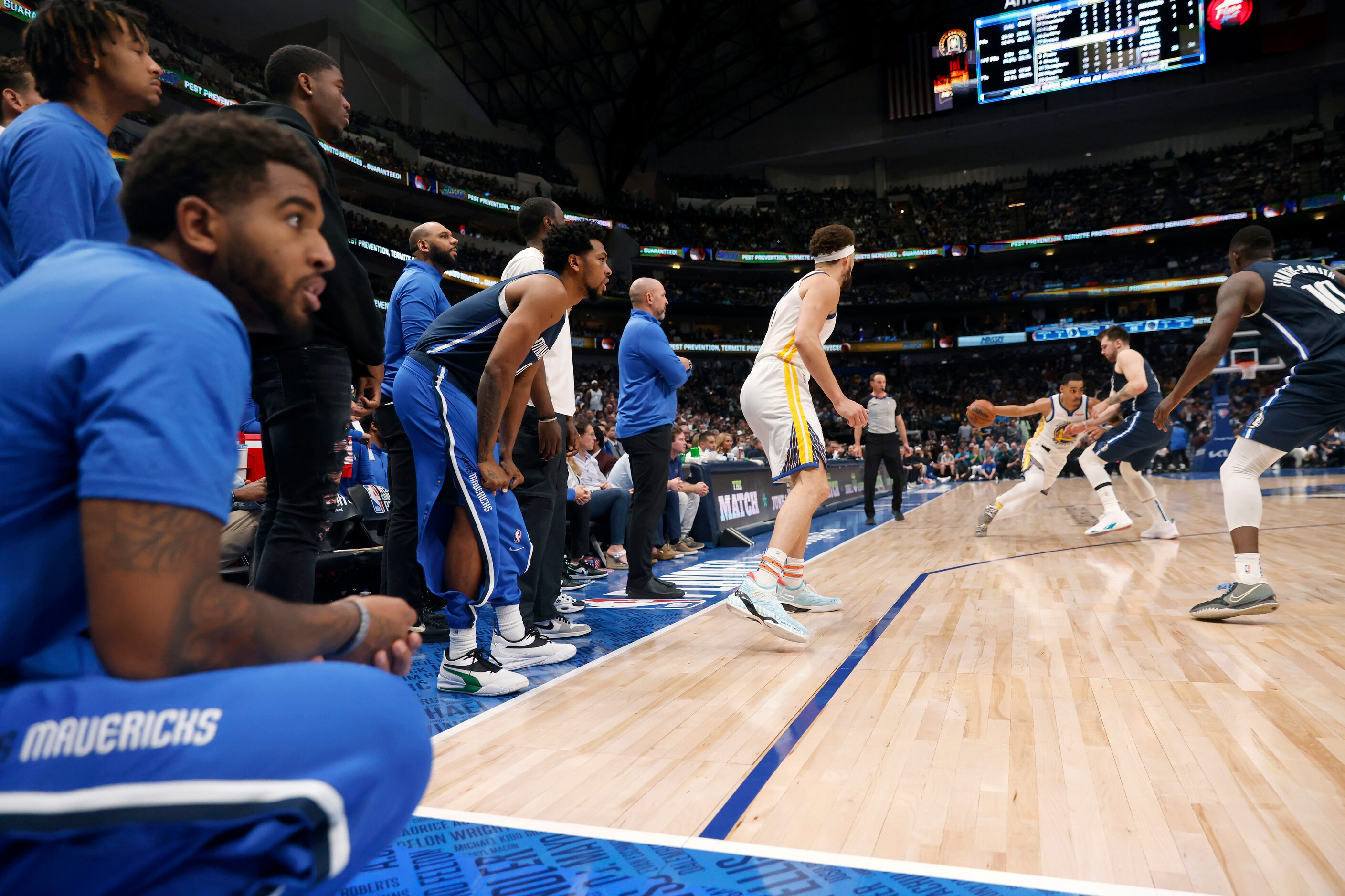 The Dallas Mavericks bench players watch their teammates compete against the Golden State...