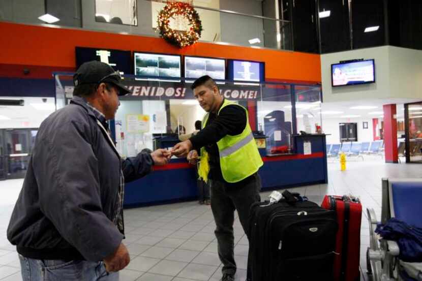 Perfecto Figueroa (izq.) recibe un boleto de equipaje antes de su viaje a Guanajuato, en la...