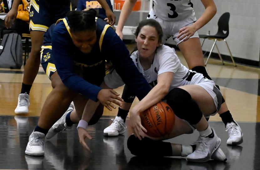 McKinney’s Karlan Moore, left, Denton Guyer’s Evie Goetz go after a loose ball in the second...