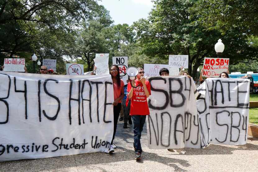 Progressive student activist Mark Napieralski, center, leads a group of people on a march on...