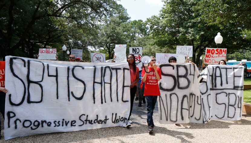 Progressive student activist Mark Napieralski, center, leads a group of people on a march on...