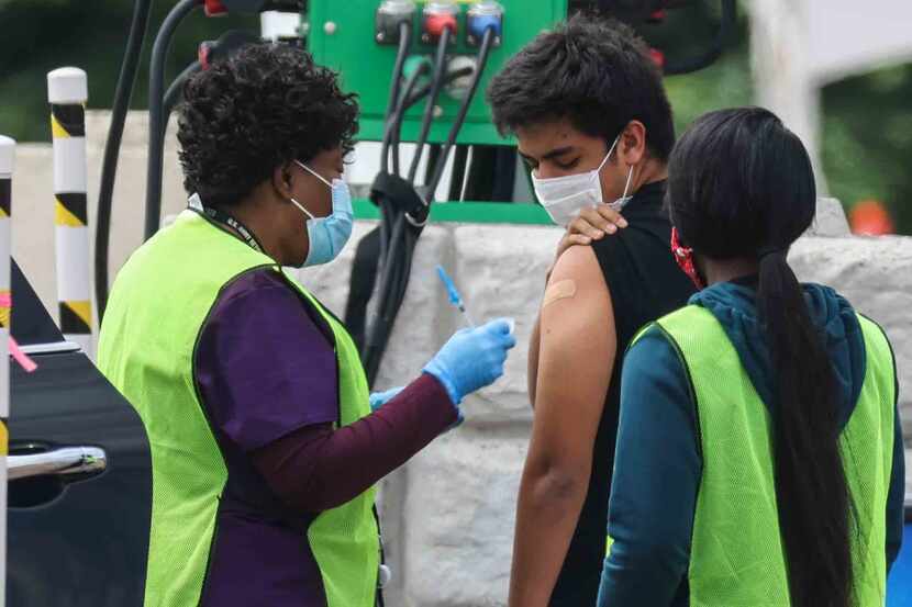 Una enfermera vacuna a un joven en Fair Park, en donde han disminuido las dosis semanales....