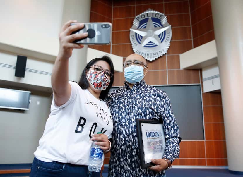 Norma Rocha takes a photo with her father, Juan Vaquero, who is holding a certificate he...