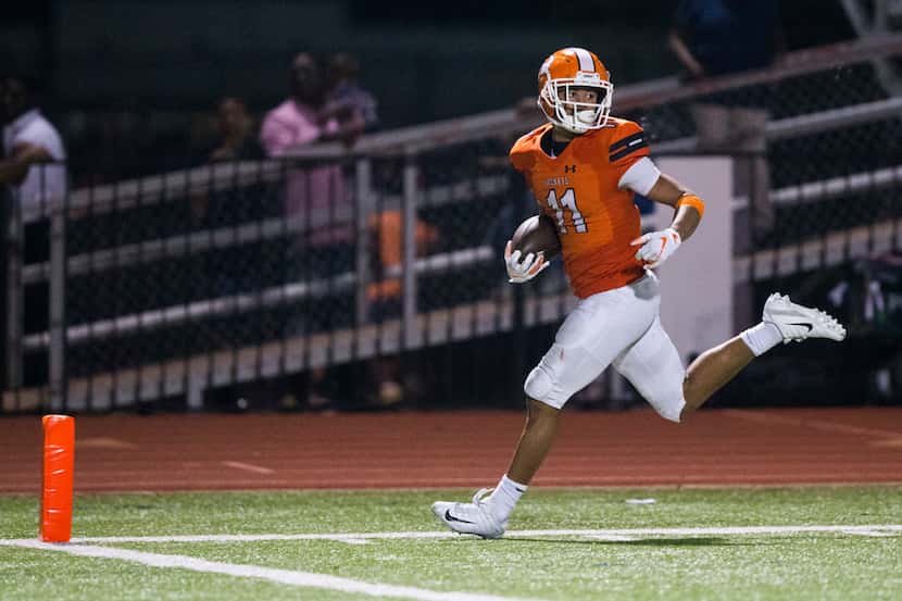 Rockwall wide receiver Jaxon Smith (11) looks back as he runs to the end zone for a...