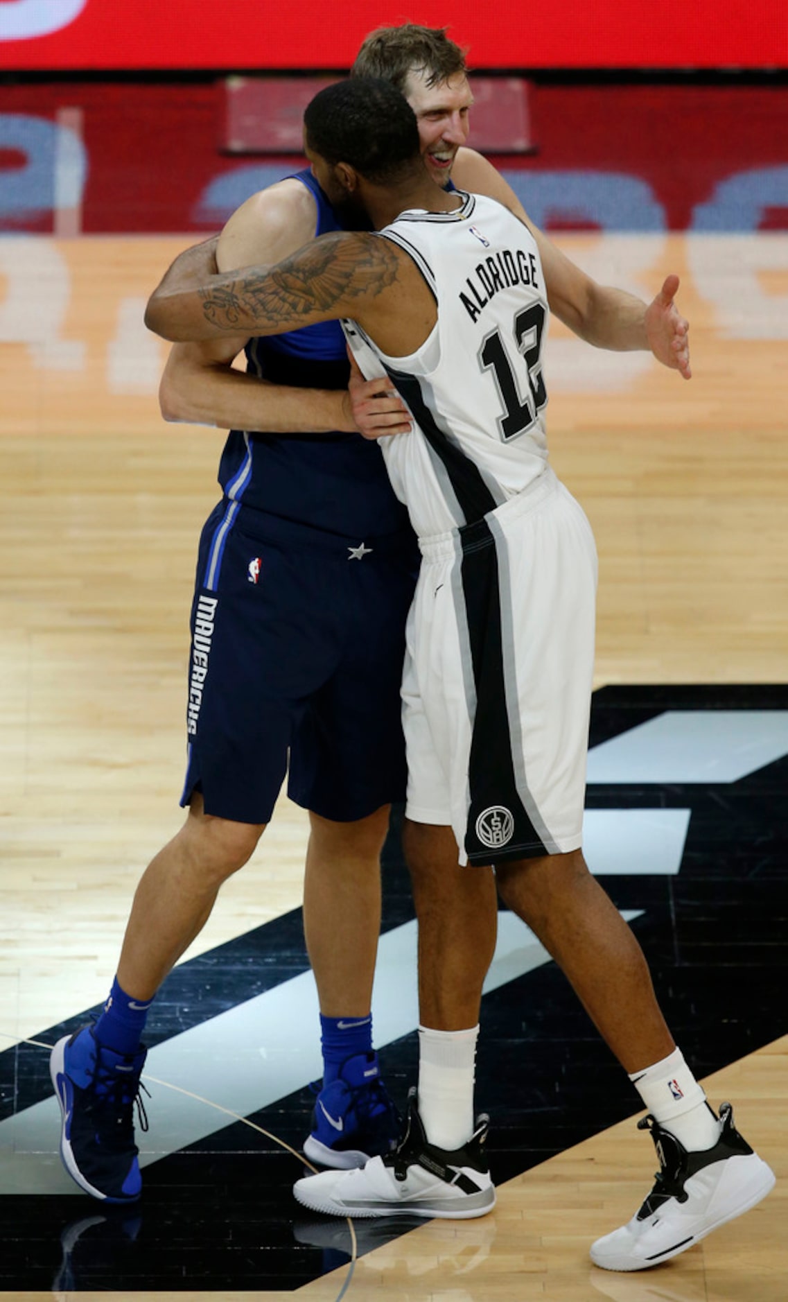 Dallas Mavericks forward Dirk Nowitzki (41) hugs San Antonio Spurs center LaMarcus Aldridge...