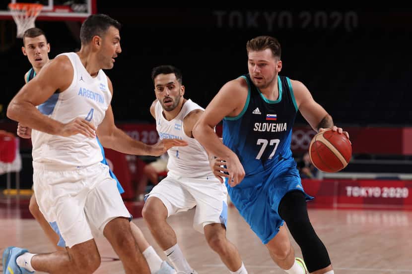 Slovenia’s Luka Doncic (77) drives down the court as he is defended by Argentina’s Luis...