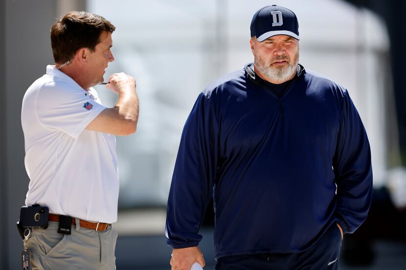 Dallas Cowboys athletic trainer Jim Maurer (left) briefs head coach Mike McCarthy as he...
