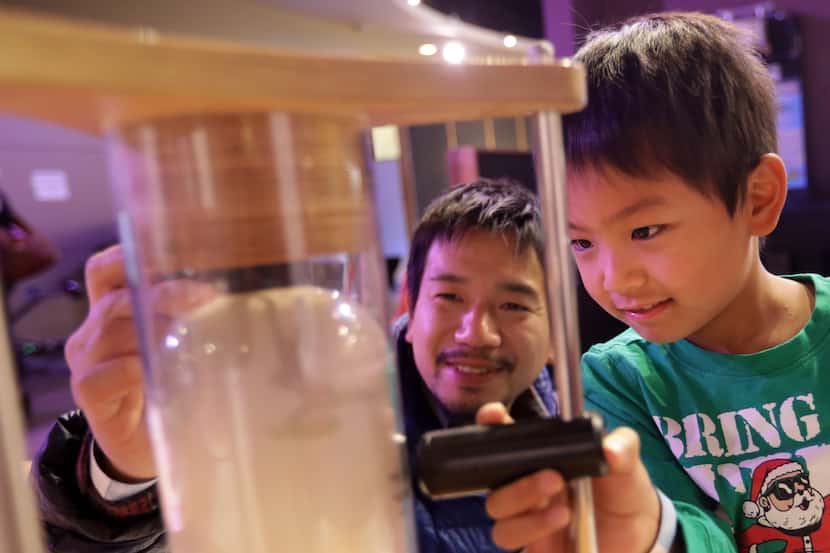 Takamichi Ono, left, and 6-year-old Masato Ono enjoy Sci-Tech Discovery Center in Frisco.