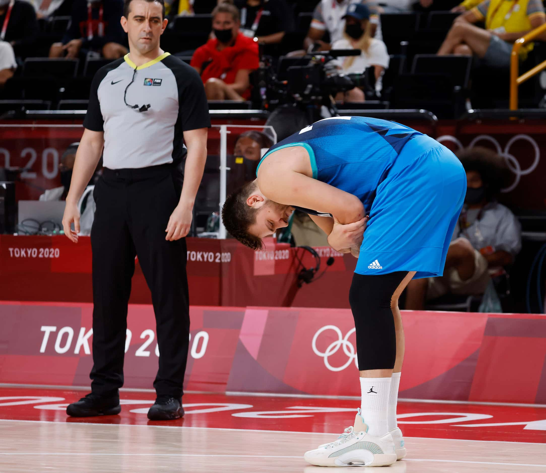 Slovenia’s Luka Doncic (77) grabs his arm near his elbow where he fell on it during a game...