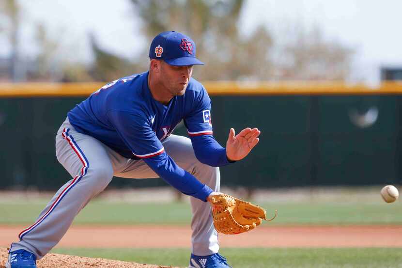 Texas Rangers pitcher Danny Duffy fields a ball during a spring training workout at the...