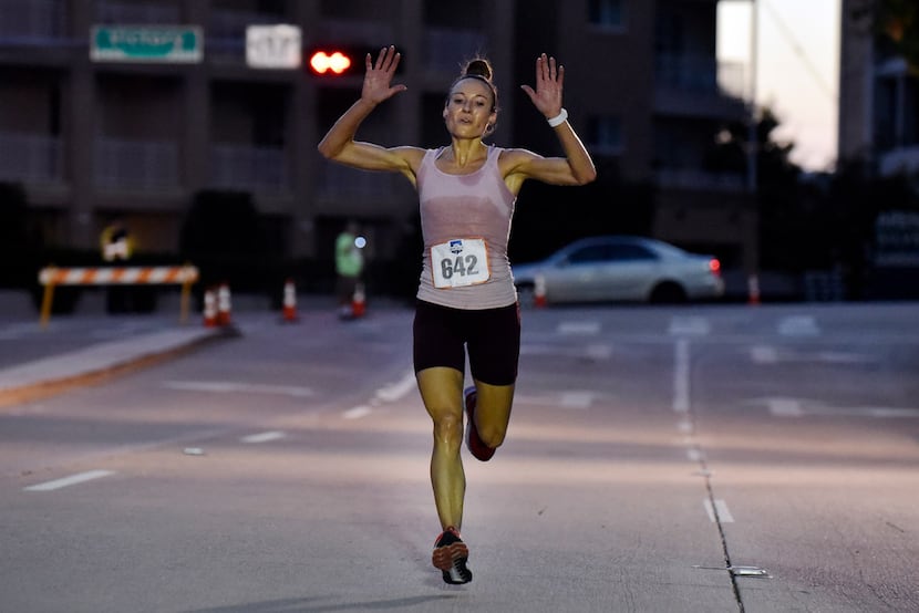 Erica Marrari, of Dallas, is the first woman to cross the finish line during the 2018 Mavs...