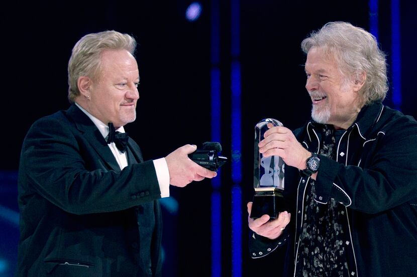 Randy Bachman, right, holds the Juno as Robbie Bachman videotapes a closeup of the trophy...