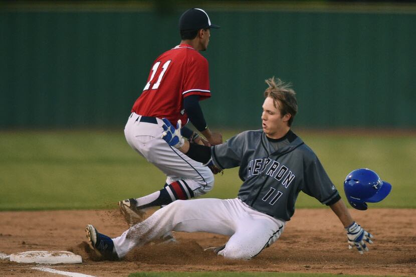 Ryan's Manny Torralba (11) waits for the throw as Hebron's Zach Deloach (11) slides into...
