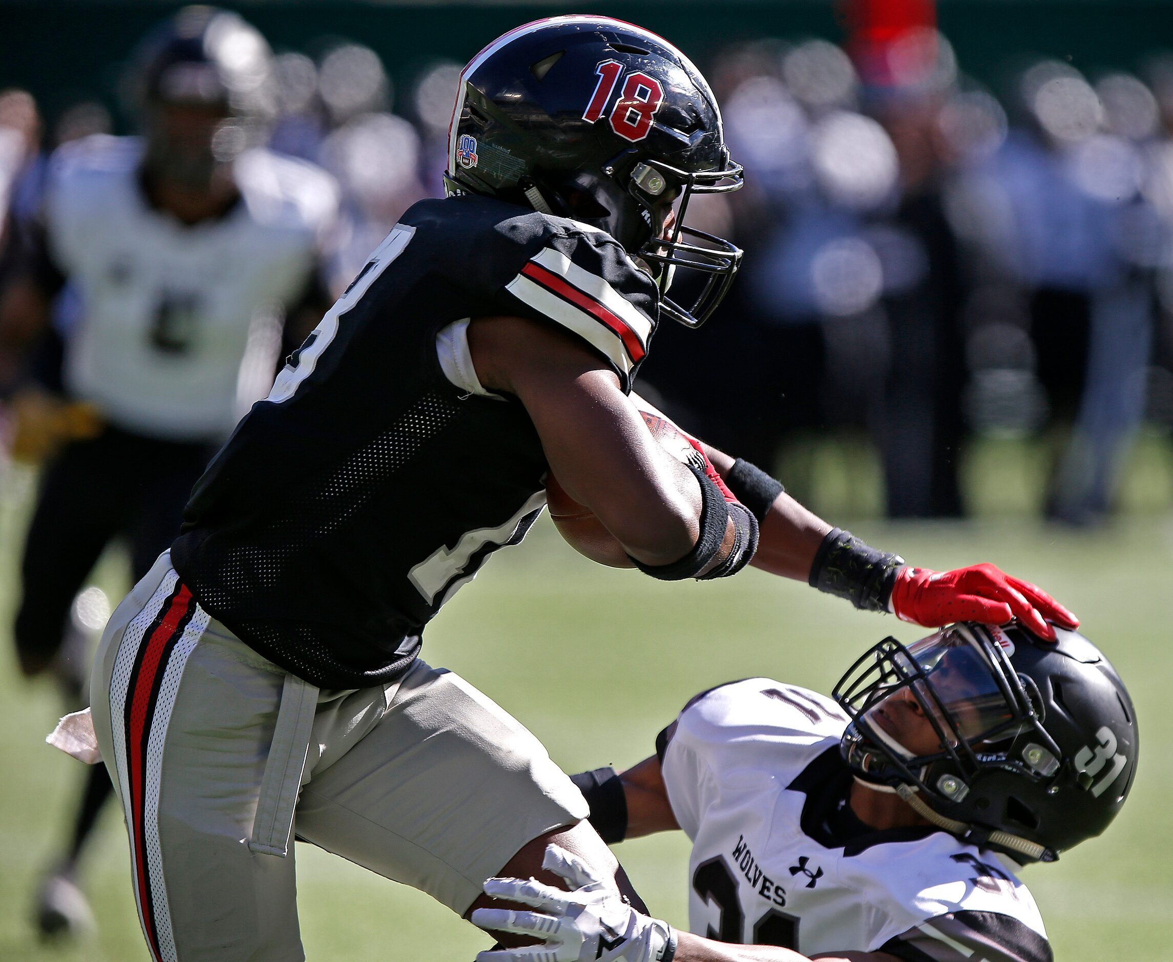 Lovejoy High School defensive back Isaiah Smith (18) gives a stiff arm to Mansfield...