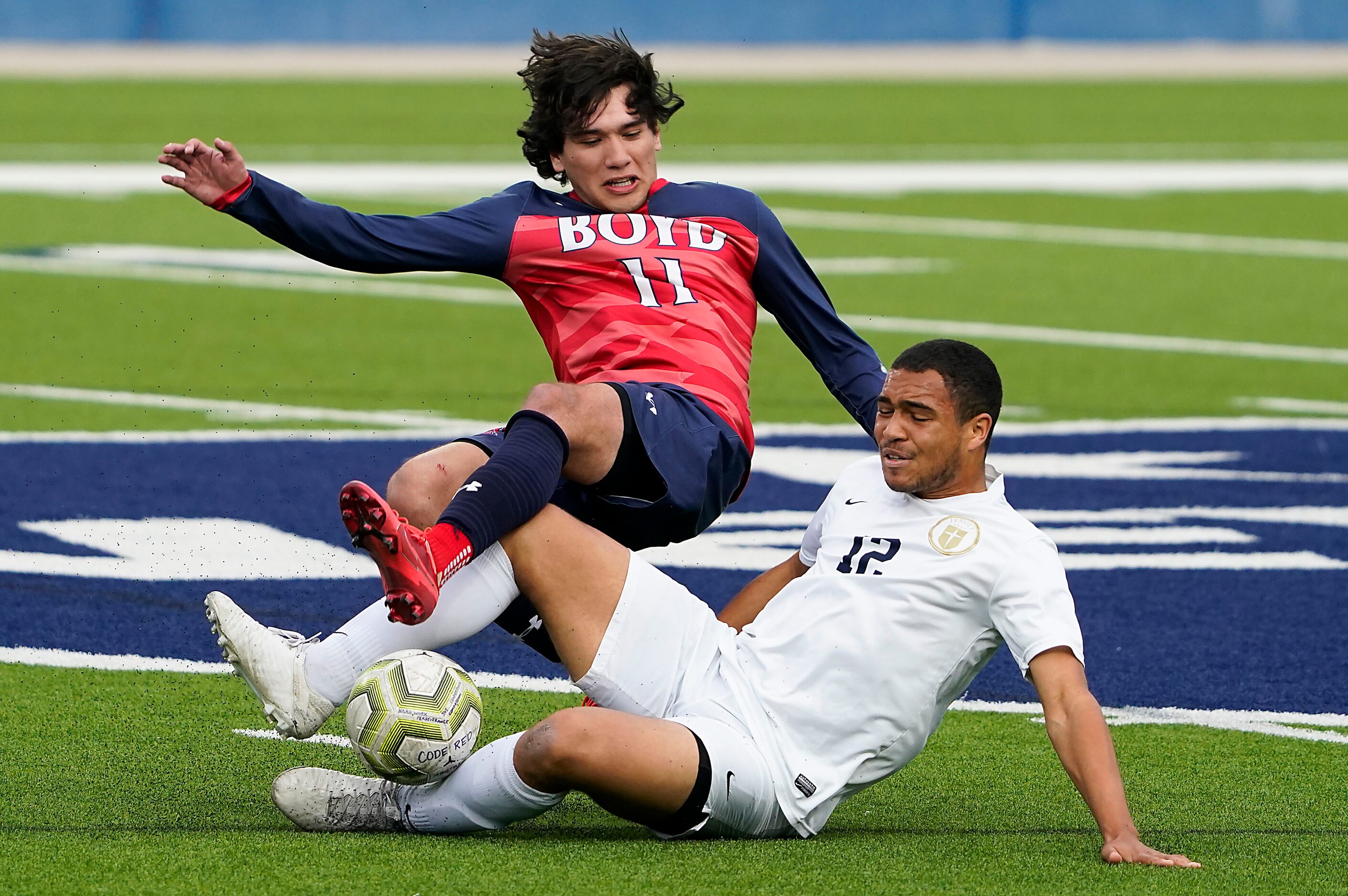 Jesuit defender Jason Davis (12) makes a sliding tackle against McKinney Boyd forward...