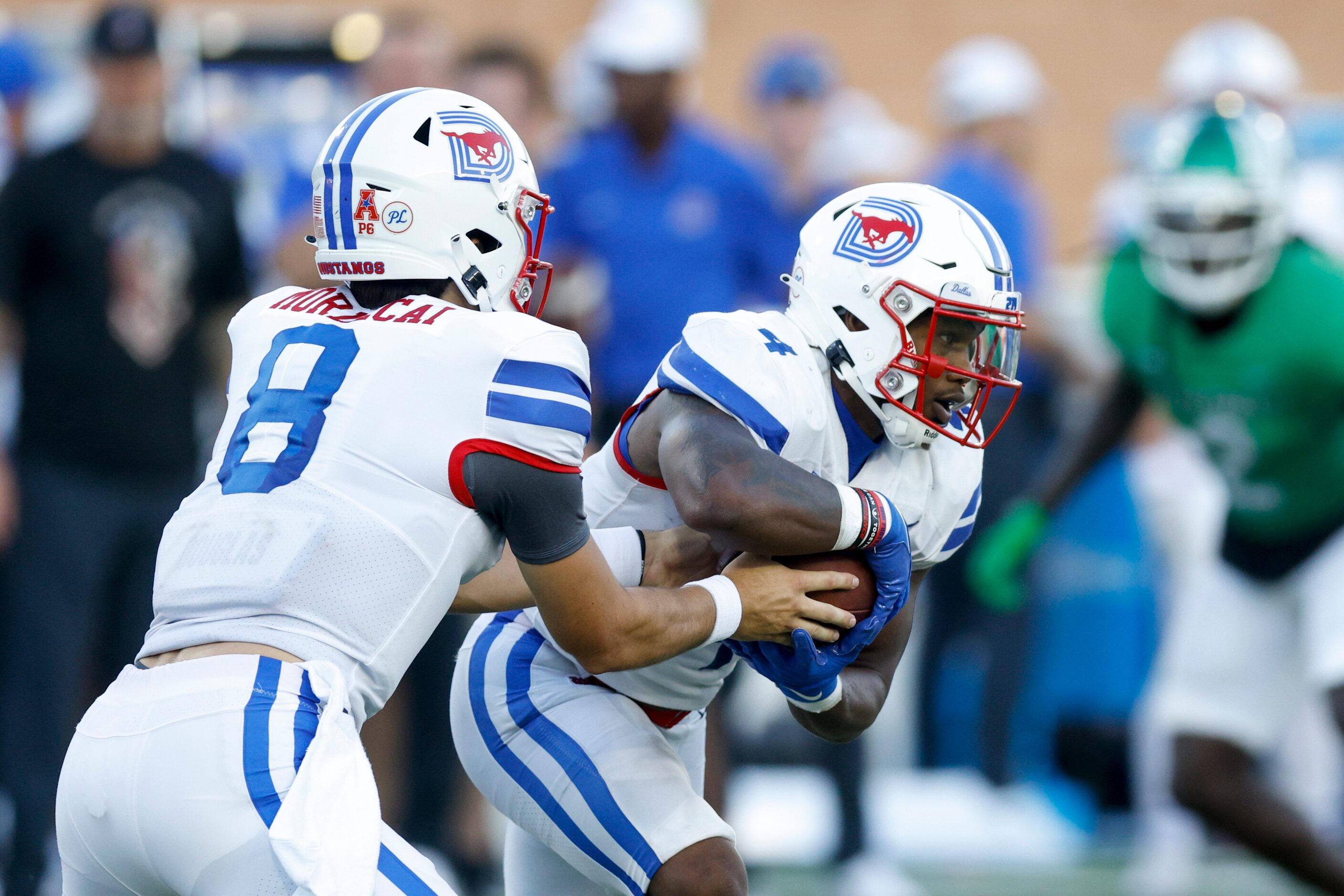 SMU quarterback Tanner Mordecai (8) hands the ball to SMU running back Tre Siggers (4)...