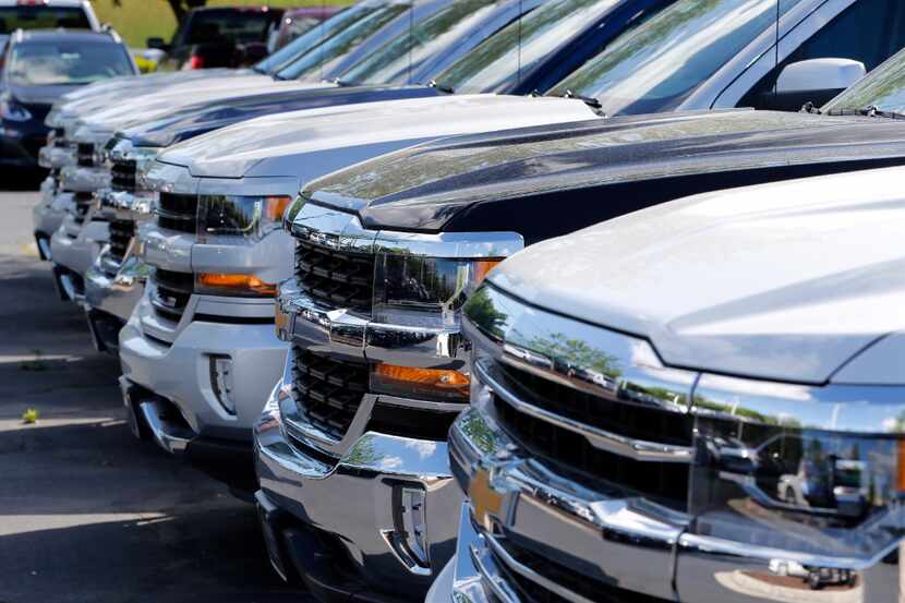 In this Wednesday, April 26, 2017, photo, Chevrolet trucks are lined up at a Chevrolet...