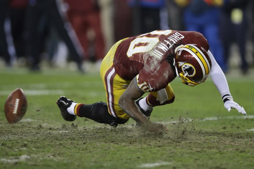 Washington Redskins quarterback Robert Griffin III falls after twisting his knee while...