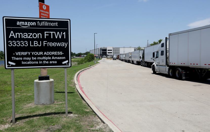 A long line of delivery trucks waits to enter the Amazon Fulfillment Center in South Dallas.