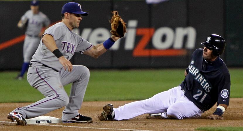 Seattle's Franklin Gutierrez steals third as 3B Michael Young takes the throw in the second...