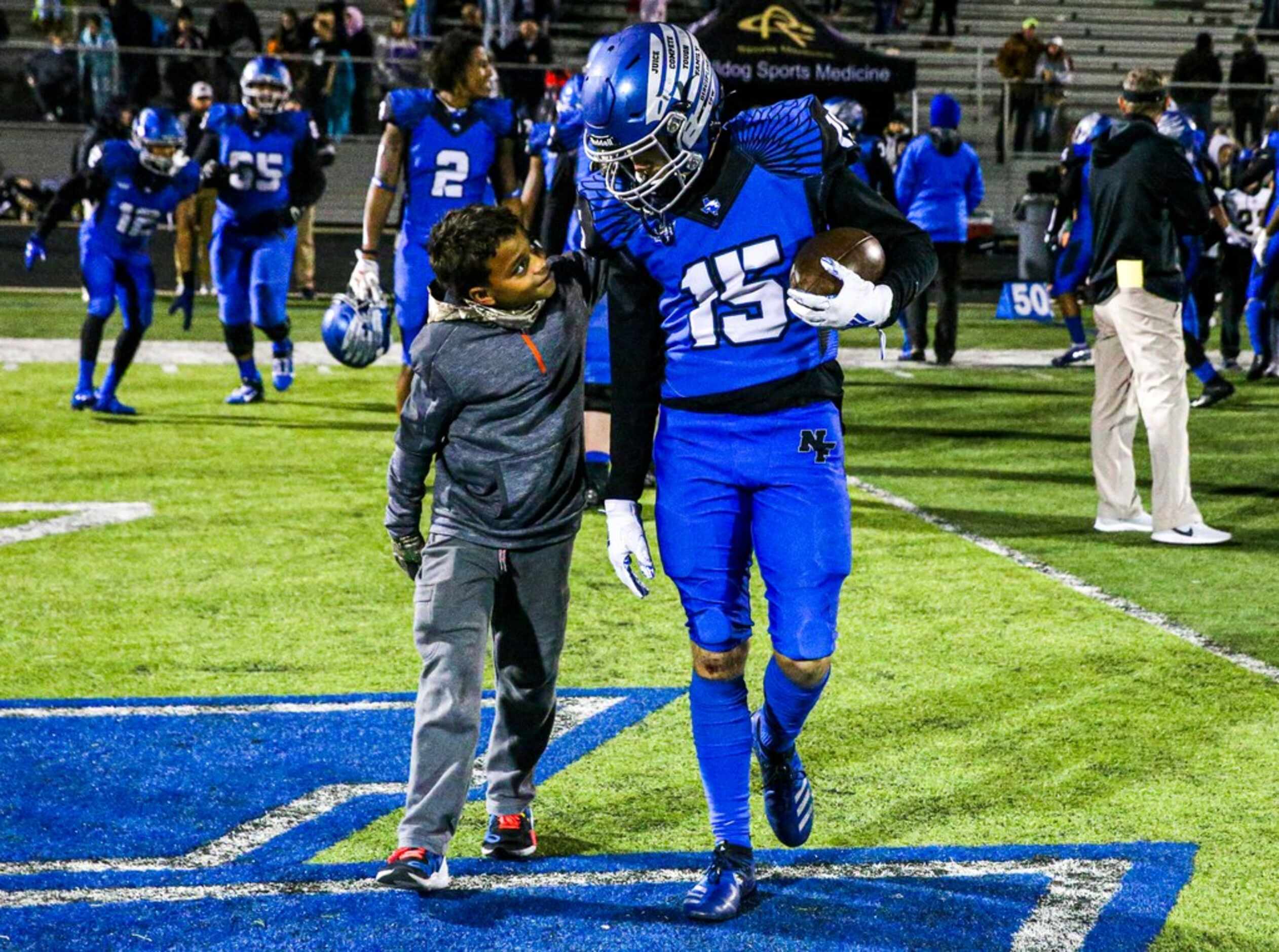 North Forneyâs ball boy Legend Luster, 11, left, chats with North Forneyâs wide receiver...