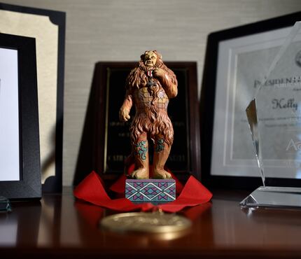 A small statue of the Cowardly Lion from the story of the Wizard of Oz sits alongside...