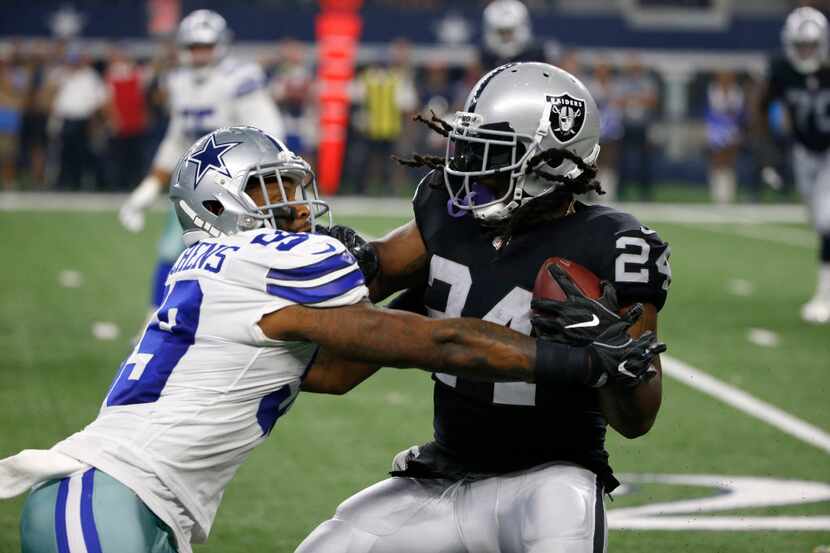 Dallas Cowboys linebacker Anthony Hitchens (59) tries to stop Oakland Raiders running back...