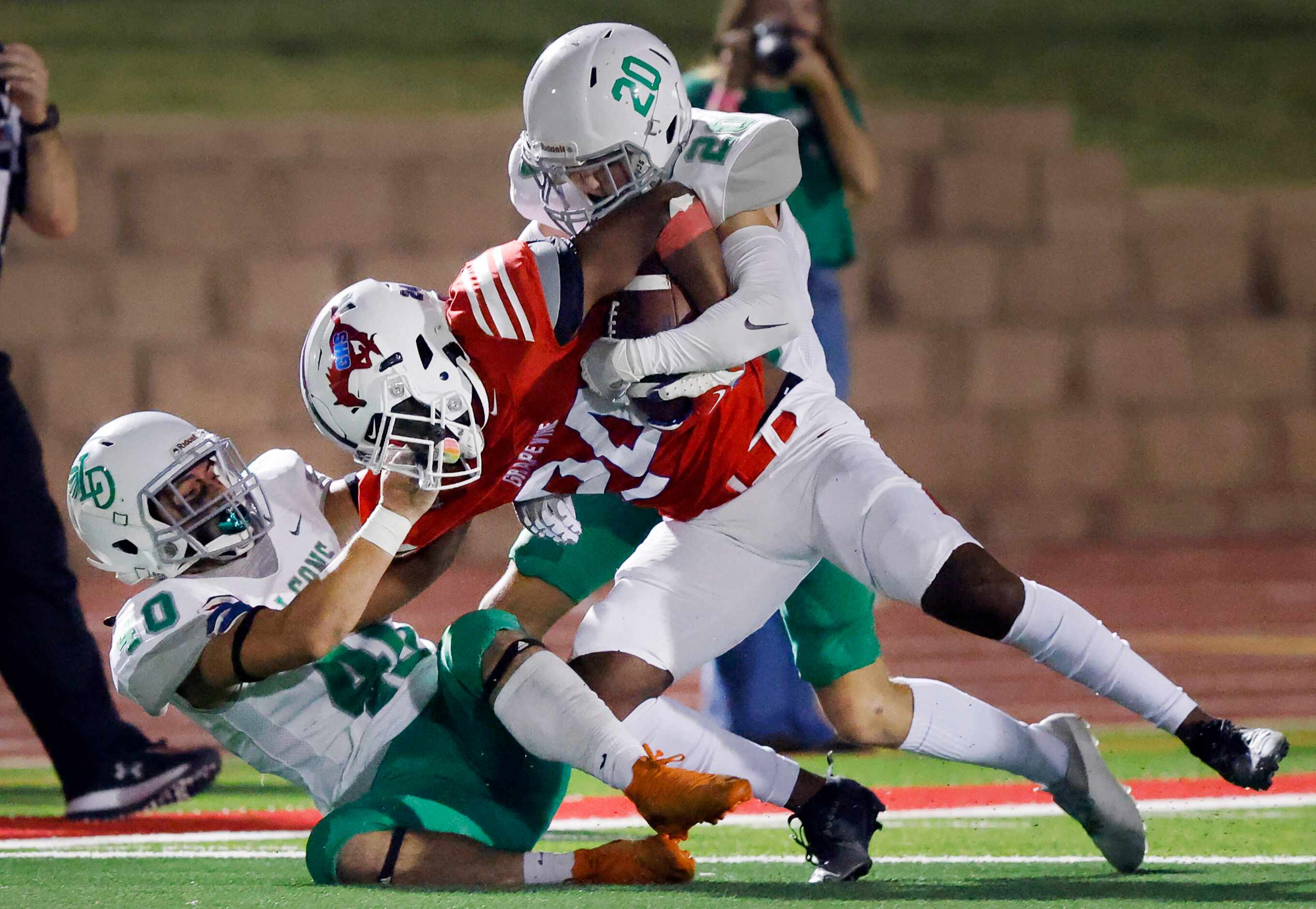 Grapevine running back Demontrez Dunn (24) is pulled down by the face mask by Lake Dallas...