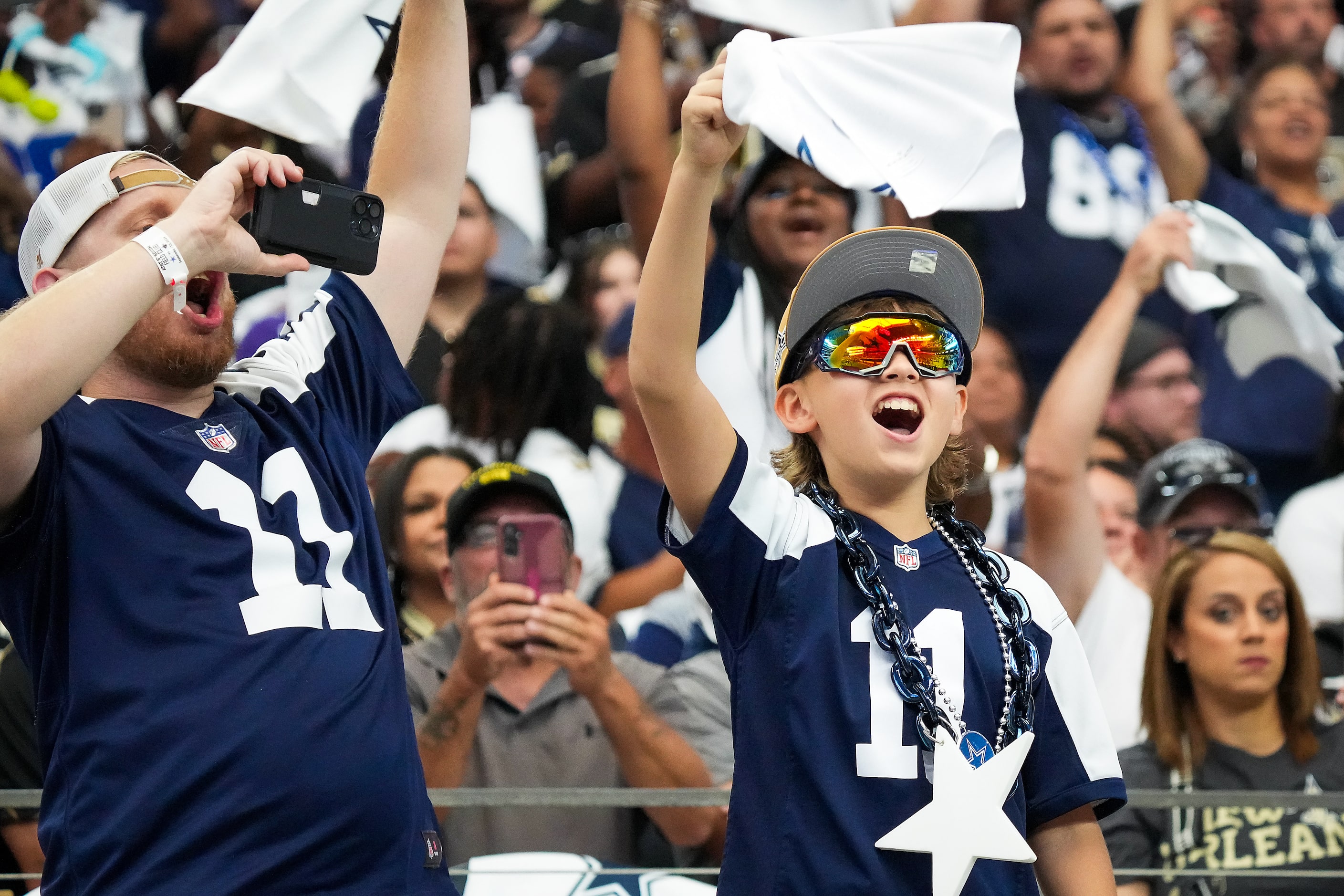 Dallas Cowboys fans cheer as their team takes the field  before an NFL football game at AT&T...