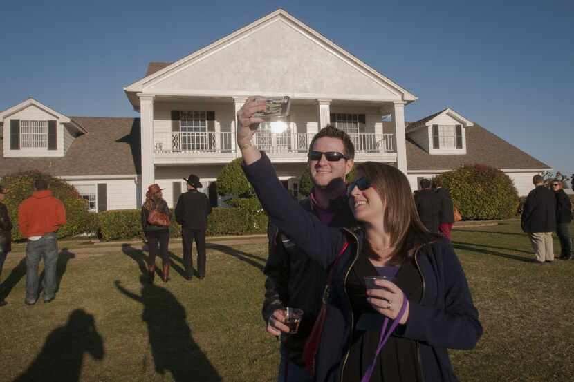 Alyssa Shepherd, front, takes a photo of she and her husband Justin in front of Southfork...