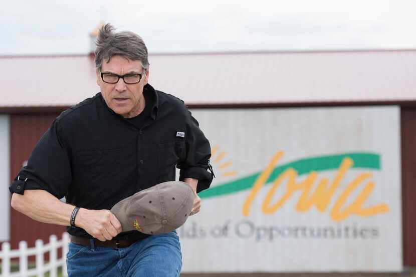 
Rick Perry sprints to the stage of the rally in Boone, Iowa, hosted by U.S. Sen. Joni...