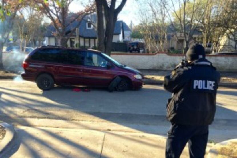  An officer photographs one of two minivans involved in the early morning break-in at the...