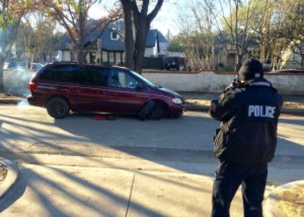  An officer photographs one of two minivans involved in the early morning break-in at the...