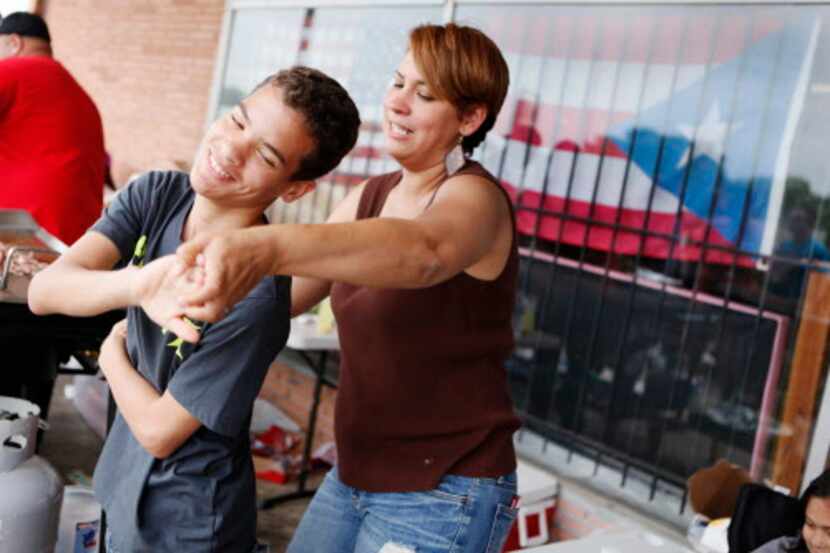 Jabes Torres, de 12 años, baila con su tía Eybel Soto durante una reciente reunión de...