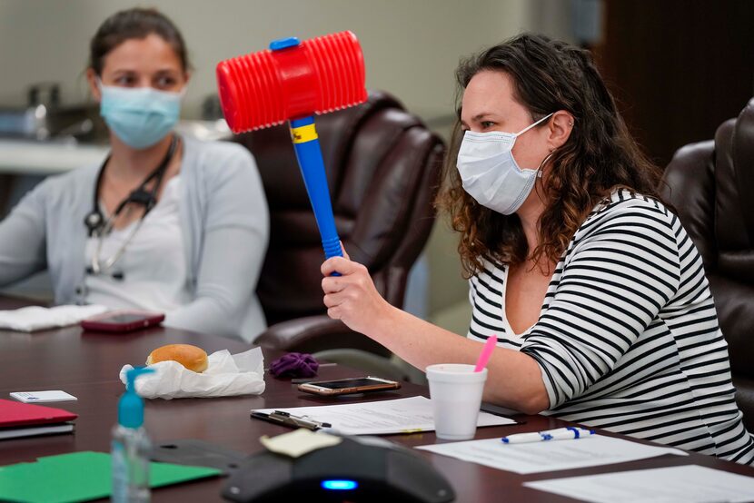 Dr. Erika Crutcher playfully gavels the monthy medical staff meeting to a close, using a toy...