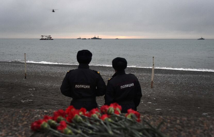 TOPSHOT - Russian police officers look at the rescue vessels searching the Black Sea outside...